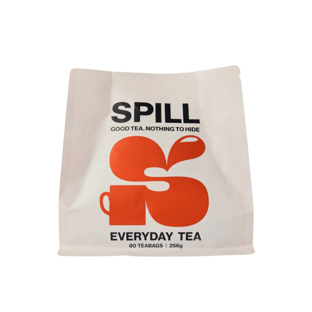 A white stand-up pouch of Spill Everyday Tea with a bold orange logo and black text on a clean white background.