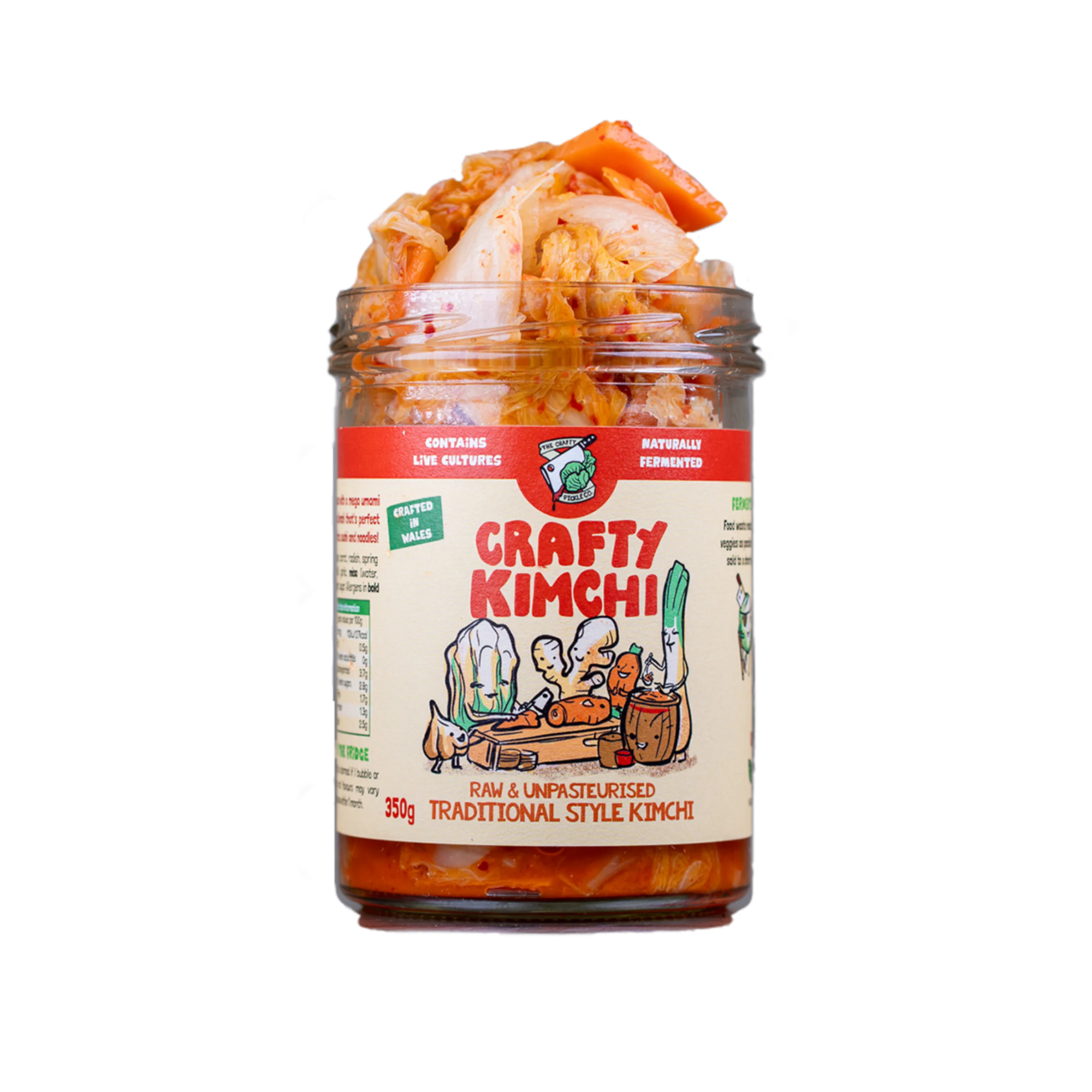 A glass jar of Crafty Kimchi traditional style kimchi with visible orange-red chili paste and pale cabbage pieces inside, set against a plain white background.