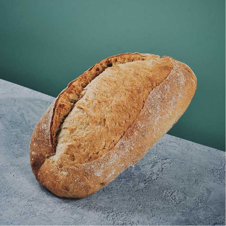 Loaf of bread on a gray surface with a teal background