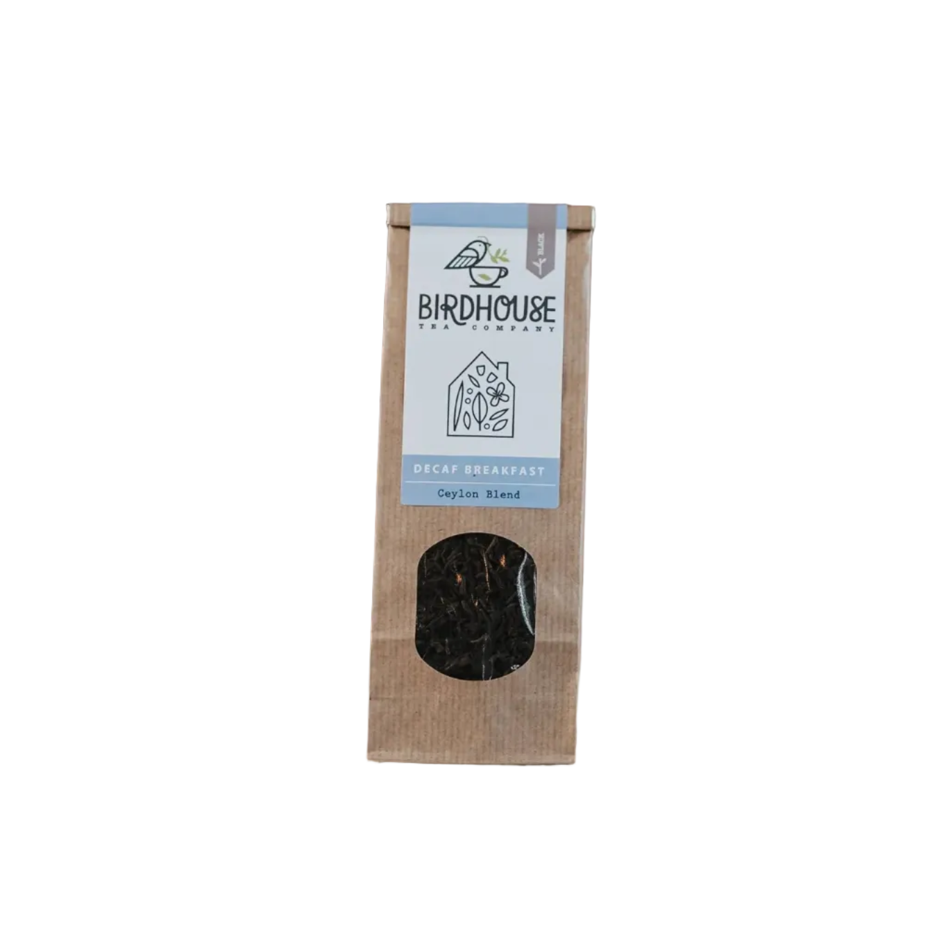 Birdhouse coffee package on a table with scattered coffee beans, plant, and brick wall in the background