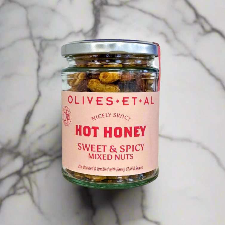 Jar of 'Hot Honey Sweet & Spicy Mixed Nuts' by Olives Et Al on a marble background