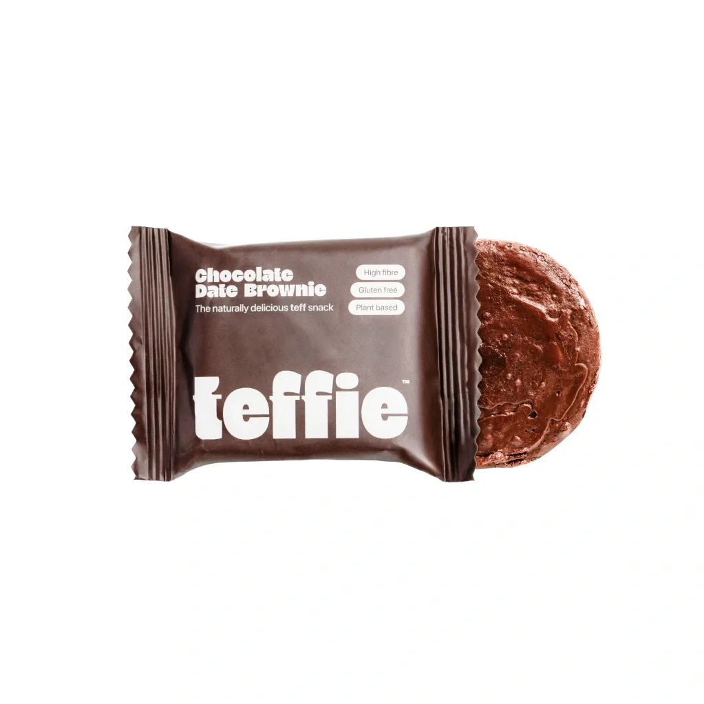 A Teffie chocolate date brownie snack, partially unwrapped to show the thick chocolate date spread, with its dark brown wrapper displaying the white 'teffie' brand logo on a clean white background.
