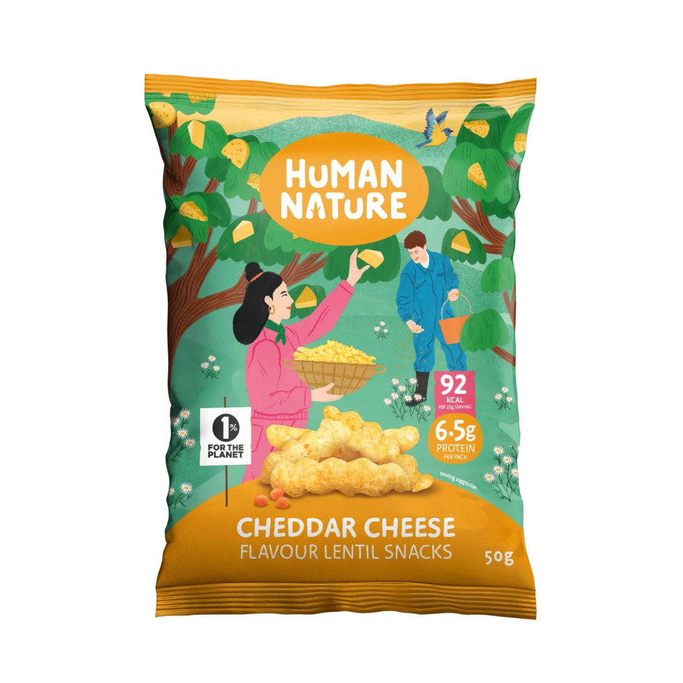 A 50g bag of Human Nature Cheddar Cheese Flavour Lentil Snacks. The packaging features a colorful illustration of a person and a man harvesting cheddar cheese from a tree, with a pile of golden-brown lentil chips at the bottom.