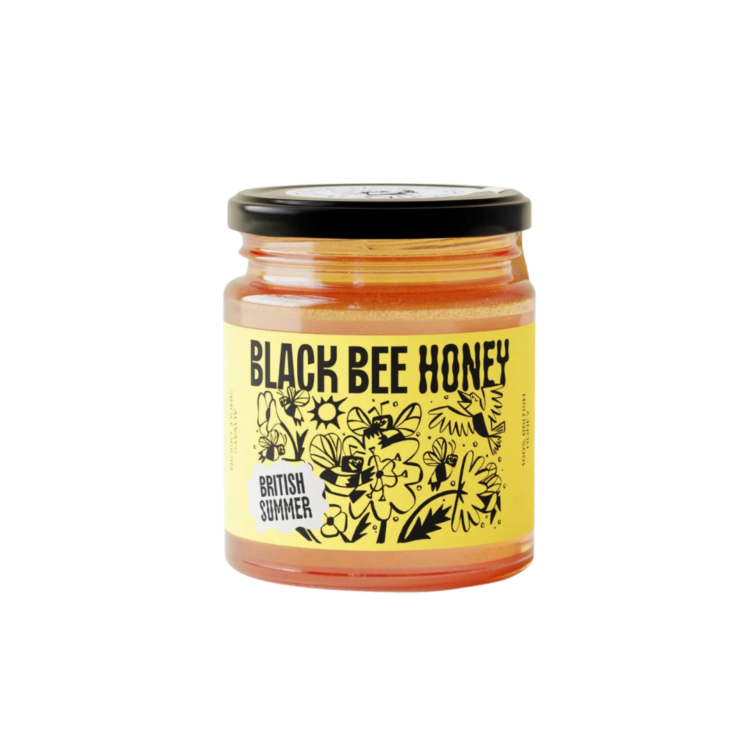 A glass jar of Black Bee Honey with a black lid and a yellow label featuring black bee illustrations and the text 'BLACK BEE HONEY' and 'BRITISH SUMMER'.